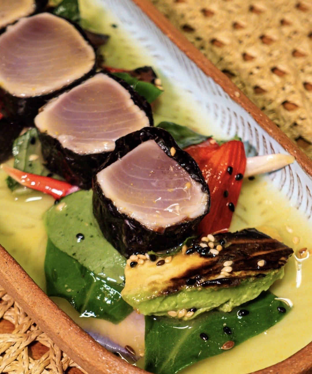Tataki du poisson du jour : médaillons saisis enveloppés d’algue nori sur un bouillon de tucupi, avec avocat grillé, piment et sésame